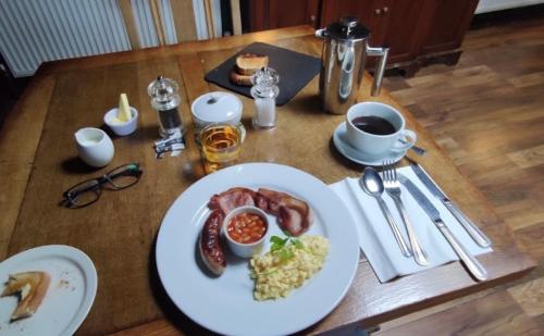 a table with a plate of breakfast food on it at The New Court Inn in Usk