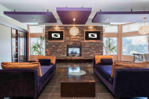 a living room with two couches and a fireplace at Sandman Hotel Penticton in Penticton