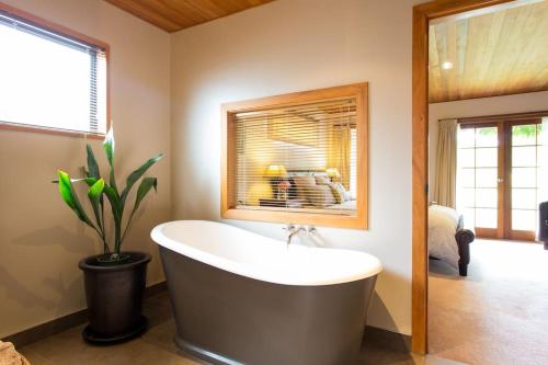 a bathroom with a tub and a potted plant at Glenorchy Lake House in Glenorchy