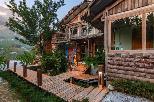 a house with a wooden deck in front of it at Toce House Tả van in Sa Pa