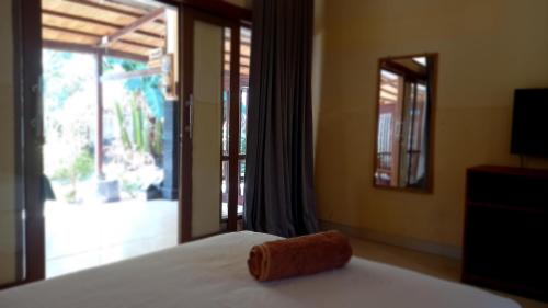 ręcznik na łóżku w pokoju z oknem w obiekcie Wisma Bunda w Gili Trawangan