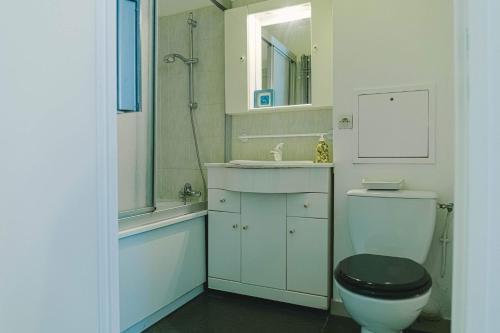 uma casa de banho com um WC, um lavatório e um chuveiro em Luka's charming apartment near Disneyland em Magny-le-Hongre