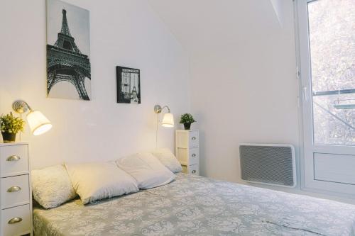 um quarto branco com uma cama e uma televisão em Luka's charming apartment near Disneyland em Magny-le-Hongre
