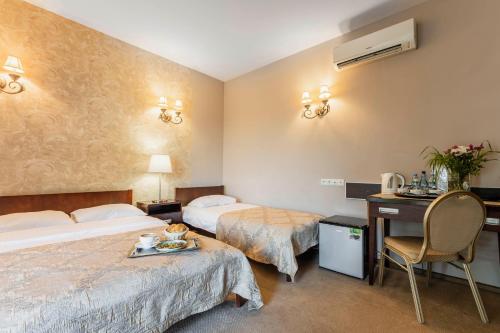 una camera d'albergo con 2 letti e una scrivania di Hotel Pod Kasztanami a Lublino
