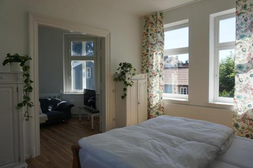 a bedroom with a bed and two windows and a couch at Rosalinde in Lüneburg