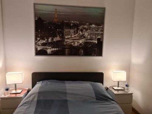 a bedroom with a picture of the eiffel tower at Appartement avec rez de jardin à Disneyland in Montévrain