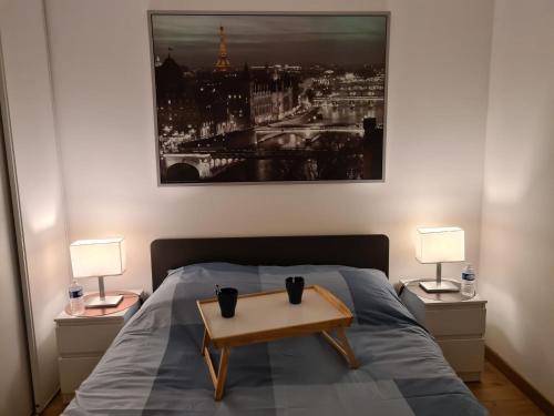a bedroom with a bed with a table on it at Appartement avec rez de jardin à Disneyland in Montévrain