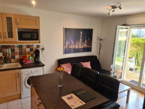ein Wohnzimmer mit einem Sofa und einer Küche in der Unterkunft Appartement avec rez de jardin à Disneyland in Montévrain