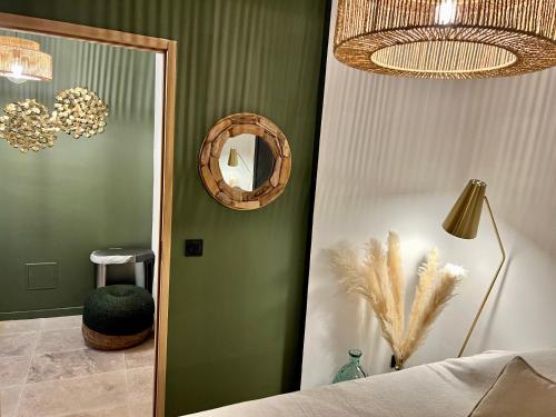 - une chambre avec un miroir et un mur vert dans l'établissement CALANQUE DE PORT MIOU, à Cassis
