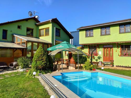 a house with a swimming pool in front of a house at Villa Real Paradise in Smižany