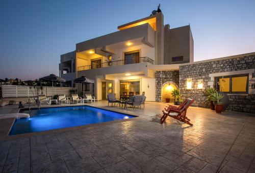 a villa with a swimming pool in front of a house at Des & Coo Luxury Villa with Private Pool in Faliraki