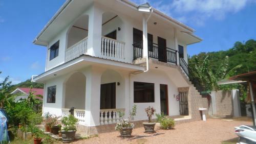 貝聖安那的住宿－Belle Rose Vue guest house，带阳台和盆栽植物的白色房屋