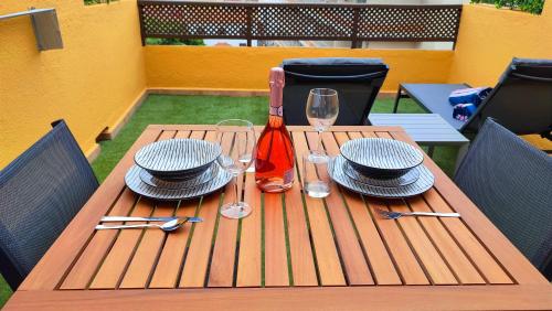 uma mesa de madeira com chapéus e pratos e copos de vinho em Marina Atico Penthouse em Puerto de la Cruz