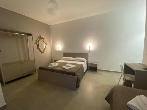 a bedroom with two beds and a mirror on the wall at AEROPORTO KATANÈ ROOMS in Catania