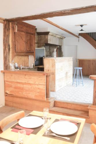d'une salle à manger avec une table et deux assiettes blanches. dans l'établissement LES REPAIRES, à Nans-sous-Sainte-Anne