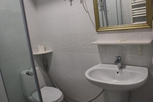 a bathroom with a sink and a toilet and a mirror at Boutique Hotel 32 in Batumi