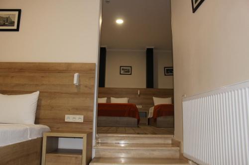 a bedroom with a bed and a room with two tables at Boutique Hotel 32 in Batumi
