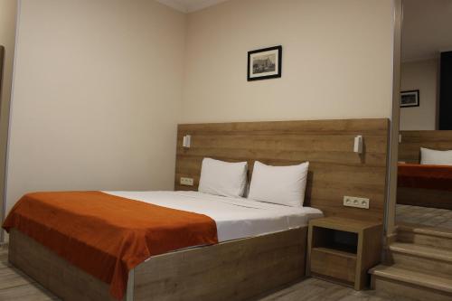 a bedroom with a large bed with a wooden headboard at Boutique Hotel 32 in Batumi