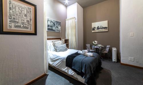 Un dormitorio con una cama y una mesa. en Craigivar Guesthouse, en Pretoria