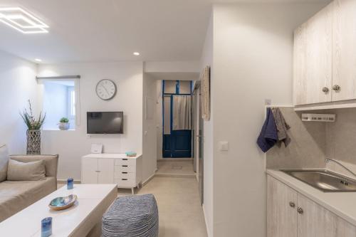 米克诺斯城Marno Mykonos Apartment的厨房以及带沙发和电视的客厅。