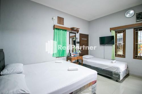 a room with two beds and a tv in it at Kedyla Homestay Syariah Patangpuluhan Malioboro Area Yogyakarta RedPartner in Ngabean