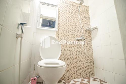 a bathroom with a toilet with a window and a mirror at Kedyla Homestay Syariah Patangpuluhan Malioboro Area Yogyakarta RedPartner in Ngabean