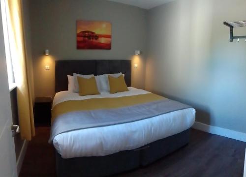 a bedroom with a large bed with yellow pillows at Kilfane Country Lodge in Kilkenny