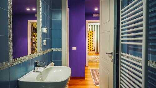 a bathroom with a sink and a purple wall at Chez Nous L'Aquila Casa vacanze in LʼAquila