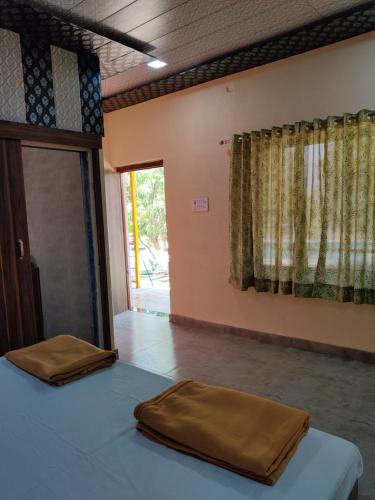 a room with a bed and a door with a window at Kastur Farm in Karjat