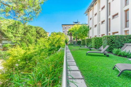 a row of benches in a park next to a building at Albergo Sorriso in Boario Terme