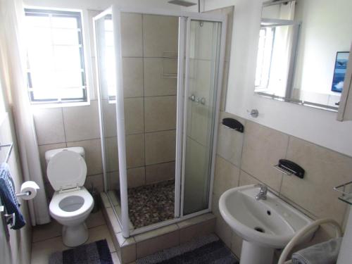 ein Bad mit einer Dusche, einem WC und einem Waschbecken in der Unterkunft Santini Lace Self Catering Unit in Plettenberg Bay