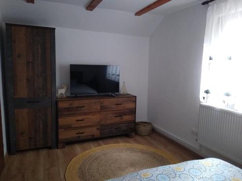 a bedroom with a television and a dresser with a bed at New and comfortable two bedroom house in Garana