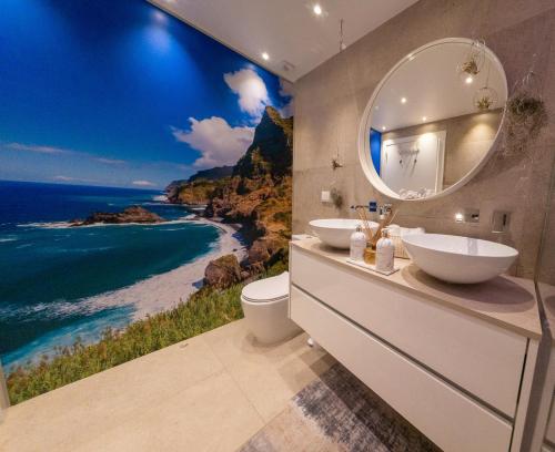 a bathroom with two sinks and a view of the ocean at Little Townsuite Funchal in Funchal