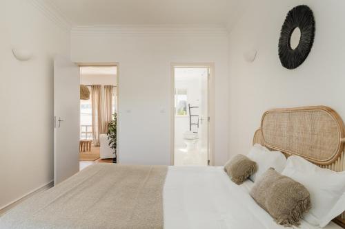 een witte slaapkamer met een groot bed met kussens bij Casa Boma Lisboa - Lighting Apartment with Private Balcony - Campolide I in Lissabon