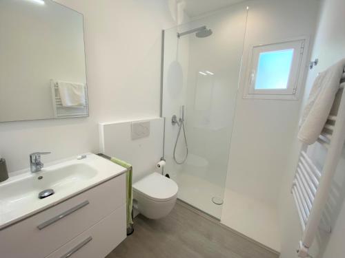 a white bathroom with a toilet and a shower at Can Valonsadero, Villa con Piscina in Es Calo