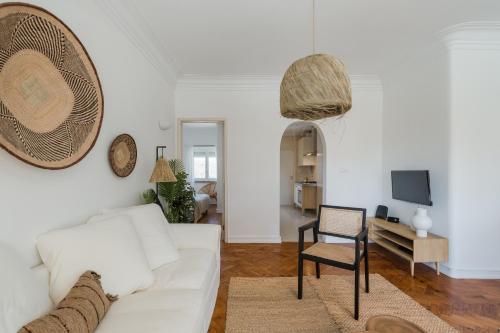 een woonkamer met een witte bank en een stoel bij Casa Boma Lisboa - Lighting Apartment with Private Balcony - Campolide I in Lissabon