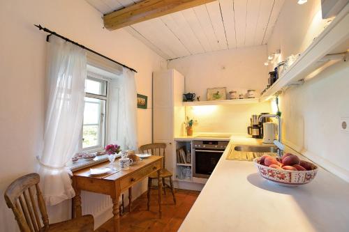 a kitchen with a table and a bowl of fruit on a counter at Pellwormhäuschen in Pellworm