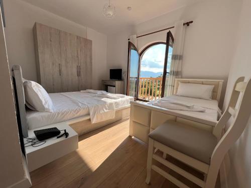a bedroom with a bed and a desk with a window at Bujtina Celiku in Burrel