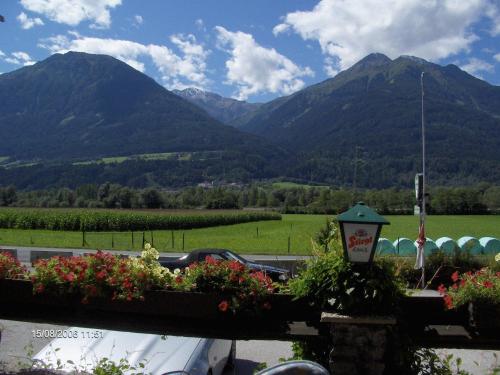 a view of mountains from a parking lot with flowers at Pension Plattenhof in Telfs