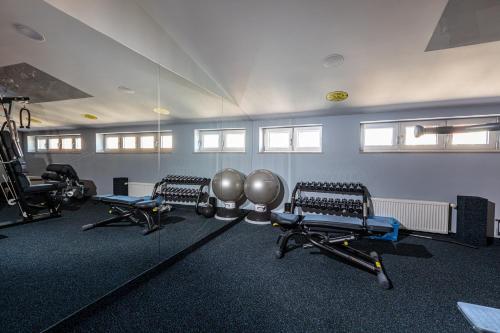 a gym with several treadmills and machines in a room at Avalon Hotel & Conferences in Rīga