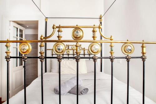 a gold and white bed with a stuffed animal on it at MeMeraki Artist Residency in Limassol