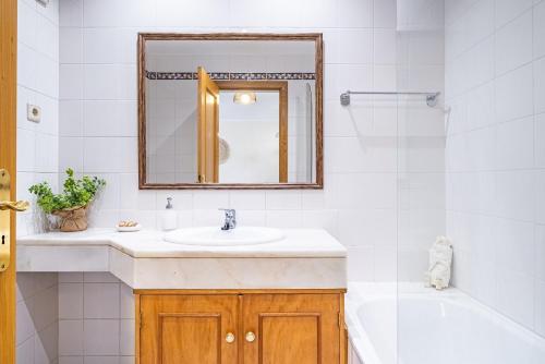 uma casa de banho com um lavatório, uma banheira e um espelho. em My Place in Funchal by Madeira Sun Travel no Funchal