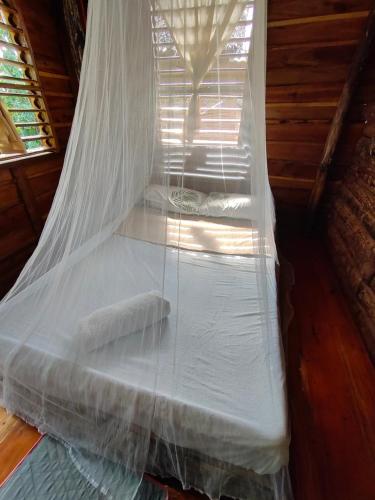 a bed with a mosquito net in a cabin at Payag n' Kapitan, Experience pinubre living in Siquijor
