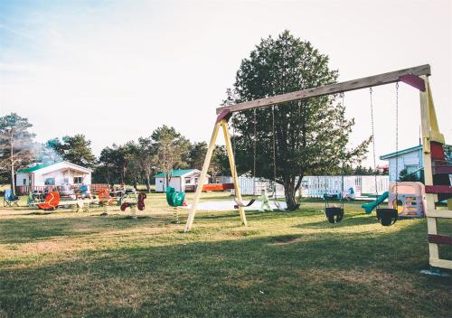 a park with a swing set in the grass at Island Life Cottages in Brackley Beach