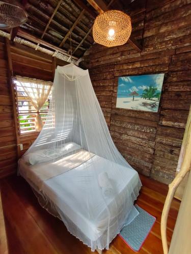 Cama en habitación con mosquitera en Payag n' Kapitan, Experience pinubre living, en Siquijor