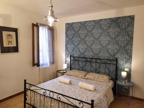 um quarto com uma cama preta e uma parede azul em Two Steps from Rialto em Veneza