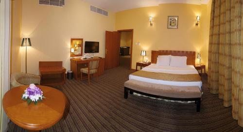 um quarto de hotel com uma cama e uma mesa em Al Massa Plus Hotel em Al Ain