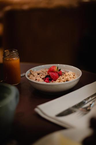 a bowl of cereal with strawberries on a table at Elite Hotel Brage - Hotel & Spa in Borlänge