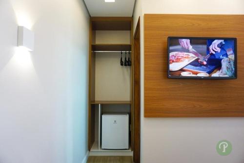 a tv on a wall in a room at Hotel Park in Valparaíso de Goiás