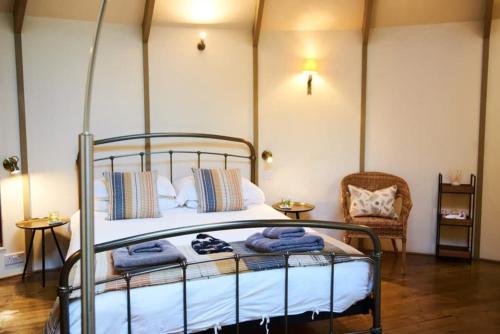 a bedroom with a bed with towels on it at Woodpecker Treehouse in Dittisham